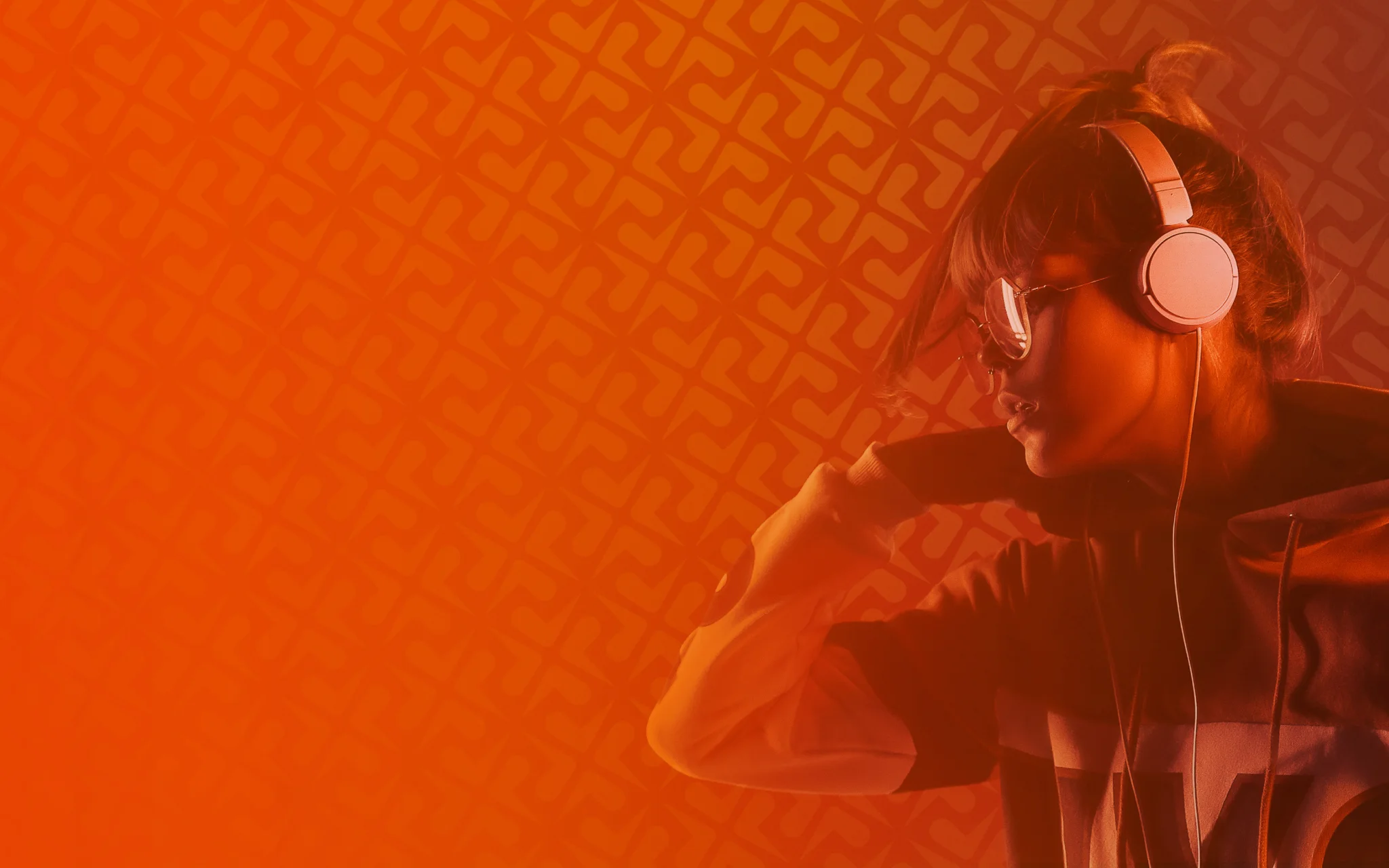 A gamer in headphones and glasses, lit in ReadyUP orange, with the brand pattern tiling the background